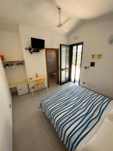 - une chambre avec un lit, un bureau et une télévision dans l'établissement Camera felice, à Campomarino