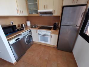 una piccola cucina con frigorifero e lavastoviglie di Casa Fuerte Aventura a Lajares