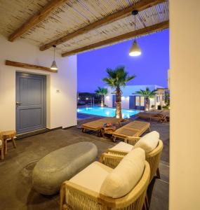 a patio with chairs and a swimming pool at night at White Dream Suites Antiparos in Antiparos