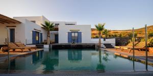 a swimming pool in front of a villa at White Dream Suites Antiparos in Antiparos