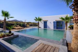 a swimming pool in a villa with palm trees at White Dream Suites Antiparos in Antiparos