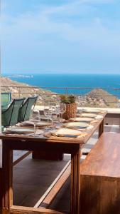 einen langen Holztisch mit Weingläsern auf dem Balkon in der Unterkunft Villa El Casot in Begur