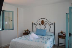 sypialnia z łóżkiem z niebieskimi poduszkami i lustrem w obiekcie Apartamentos El Aljibe Relax Tourist Cordoba w Kordobie