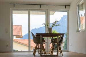 stół i krzesła w pokoju z dużym oknem w obiekcie Elmi 22 w mieście Wals-Siezenheim
