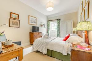 Dormitorio con cama, escritorio y TV en Tiger Inn - Grace en Eastbourne