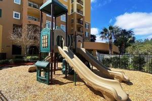um parque infantil com um escorrega em frente a um edifício em Exquisite 3 Bdr Condo Minutes to Disney em Orlando