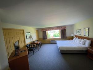 a hotel room with a bed and a desk and a television at Otsego Resort in Gaylord +53 photos