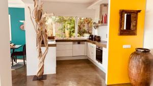 a kitchen with yellow walls and a vase in the middle at Villa El Casot in Begur
