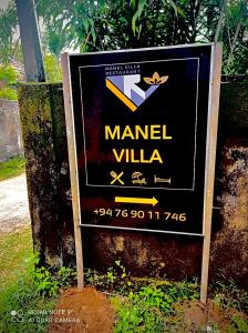 a sign for a manial villa on a field at Manel Villa in Bentota