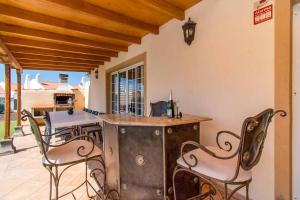een buitenkeuken met stoelen en een eiland in een huis bij Villa Guapa in San Miguel de Abona