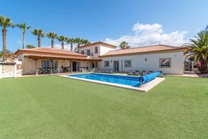 een huis met een grote tuin met een zwembad bij Villa Guapa in San Miguel de Abona