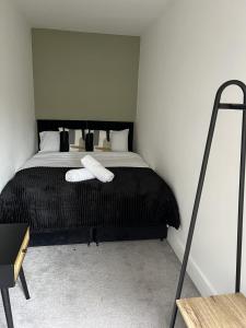 um quarto com uma cama com duas toalhas brancas em Warner Brothers House em Watford