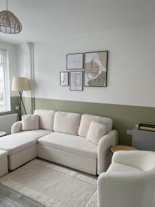 uma sala de estar com um sofá branco num quarto em Warner Brothers House em Watford