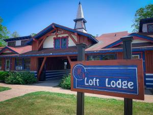 una señal frente a un edificio con un lodge luminoso en Otsego Resort en Gaylord