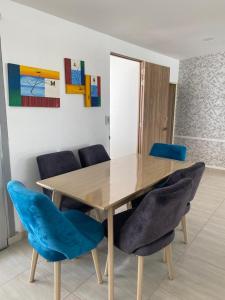 una mesa de madera con sillas azules en una habitación en Hermosa Casa Campestre, en Cúcuta