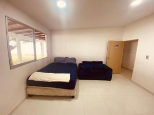 ククタにあるHermosa Casa Campestreのベッドルーム(ベッド1台、青いソファ付)