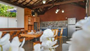 a kitchen with a wooden table and chairs and a counter at Flat com Piscina no Centro de Tiradentes in Tiradentes