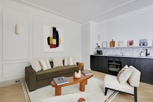 un soggiorno con un divano e un tavolo di TheLander - Serviced Apartments in Louvre - Rivoli a Parigi Altre 28 foto