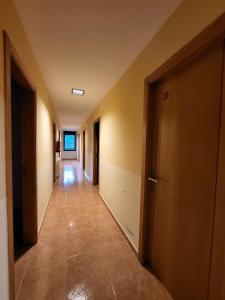 un corridoio vuoto con porte e pavimento piastrellato di COMPLEXO TURISTICO PONTE MOURULLE 