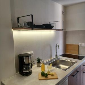 a kitchen counter with a sink and a blender at nisaki rooms & apartments in Methana