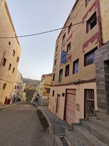 una calle vacía en un viejo pueblo con edificios en فندق آل الشيخ أحمد en Targuist