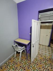 um quarto com uma cadeira, uma mesa e uma porta em فندق آل الشيخ أحمد em Targuist