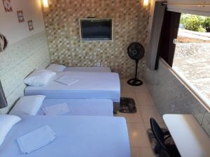 Pokój z 3 łóżkami i telewizorem na ścianie w obiekcie Mar & Sol Residence-Praia da Penha w mieście João Pessoa