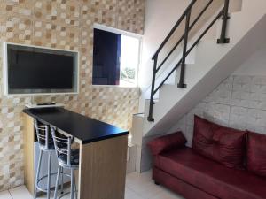 salon z czerwoną kanapą i telewizorem z płaskim ekranem w obiekcie Mar & Sol Residence-Praia da Penha w mieście João Pessoa