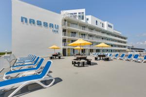 a group of chairs and tables and umbrellas on a beach at Wildwood Condo with Pool Access - Walk to Beach! in Wildwood