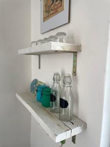 two glass bottles on a wooden shelf on a wall at Appartamento in Piazza Spolethome in Spoleto +51 photos