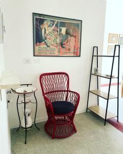 Appartamento in Piazza Spolethome في سبوليتو: كرسي احمر وطاولة في الغرفة