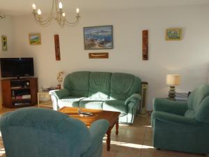 濱海聖西的住宿－海上的圣西爾公寓，客厅配有两张绿色沙发和一张咖啡桌