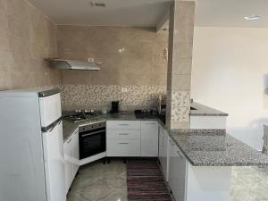 Harqalah的住宿－Maison Eline，厨房配有白色橱柜和白色冰箱。