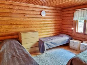 - une chambre avec 2 lits dans une cabane en rondins dans l'établissement Holiday Home Saarenranta by Interhome, à Koivisto