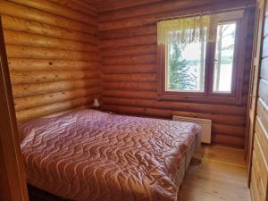 a bedroom with a bed in a log cabin at Holiday Home Saarenpää by Interhome in Koivisto +10 photos