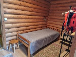a bedroom with a bed in a log cabin at Holiday Home Saarenpää by Interhome in Koivisto