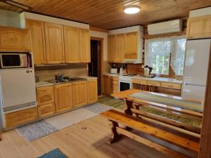 a kitchen with wooden cabinets and a wooden table at Holiday Home Saarenpää by Interhome in Koivisto