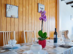 a table with a bottle of wine and a purple flower at Apartment Christiania 2 L3 by Interhome in Nendaz