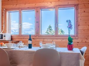 a dining room with a table with a bottle of wine at Apartment Les Chouettes 11 by Interhome in Nendaz