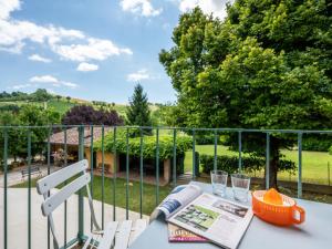 une table avec un livre et deux chaises sur un balcon dans l'établissement Apartment Cascina Virginia-2 by Interhome, à Vigliano d'Asti
