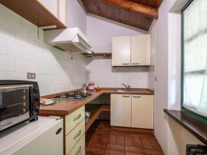 - une petite cuisine avec des placards blancs et un four micro-ondes dans l'établissement Apartment Cascina Virginia-2 by Interhome, à Vigliano d'Asti