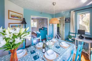 niebieska jadalnia ze stołem i krzesłami w obiekcie Fairstead Cottage by Big Skies Cottages w mieście Holt
