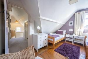 a bedroom with a bed and a dresser and a bed and a room at Fairstead Cottage in Holt