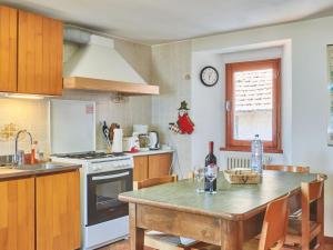 Una cocina con una mesa con sillas y un reloj en la pared. en Apartment Luciana by Interhome, en Pianello Del Lario