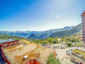 an aerial view of a building with mountains in the background at Apartment Pegase Phenix-39 by Interhome in Le Corbier