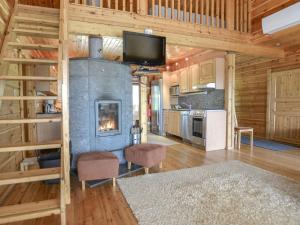 a living room with a fireplace in a log cabin at Holiday Home Kannelpirtti 2 by Interhome in Puromäki