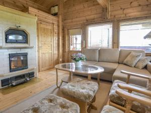 a living room with a couch and a fireplace at Holiday Home Kannelpirtti 1 by Interhome in Puromäki