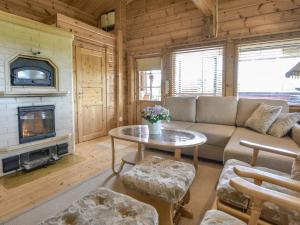 Una sala de estar con un sofá y una chimenea. en Holiday Home Kannelpirtti 1 by Interhome, en Puromäki