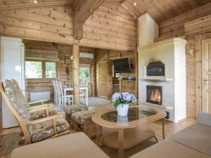 a living room with a fireplace in a log cabin at Holiday Home Kannelpirtti 1 by Interhome in Puromäki