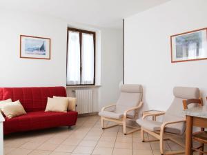 a living room with a red couch and chairs at Apartment Ca' Bottrigo-2 by Interhome in Bardolino